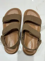 Sandalias color beige con ajuste de velcro en capellada y talón, plantilla acolchada y suela de goma antideslizante. Horma chica.