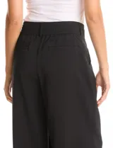 Pantalón palazzo de tiro alto en color verde militar, con diseño de doble abotonadura frontal, pinzas en la cintura y pierna ancha. Cuenta con cintura elástica en la parte posterior para mayor ajuste y bolsillos laterales funcionales.