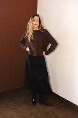 Cardigan de punto color marrón con destellos de lurex, de corte holgado, cuello redondo y cierre frontal con botones.