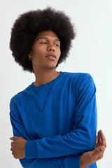 Remera de manga larga con cuello redondo, confeccionada en tejido de algodón y poliéster, con puños elásticos en las mangas.