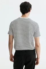 Remera de algodón liviano con diseño de rayas horizontales en blanco y negro, cuello redondo ribeteado y corte ajustado.