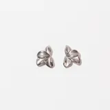 Par de caravanas plateadas con forma de flor de tres pétalos.