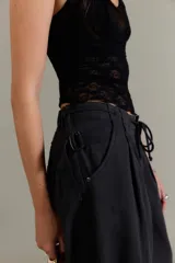 Pantalón chino de tiro bajo, color negro, pierna muy ancha, con cintura elástica con cordón ajustable y pinzas en la parte superior.