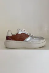 Zapatillas deportivas con plataforma, combinando texturas y colores: cuero marrón con relieve de cocodrilo, cuero plateado metalizado y detalles en color vino/bordeaux y blanco envejecido. Incluye cordones de color beige claro.
