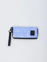 Billetera azul con estampado de flores blancas y detalles en naranja. Tiene cierre de cremallera, correa de mano y logo de la marca en el frente.