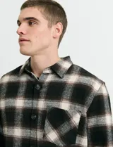 Sobrecamisa de manga larga con diseño a cuadros, cuello camisero y bolsillo frontal. Confeccionada en tejido de poliéster y algodón, sin forro.