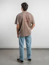 Remera oversize de algodón color negro con efecto lavado. Presenta un estampado gráfico en la espalda con la frase 'Freeze the moment' y un diseño de cámara fotográfica en tonos rojizos.