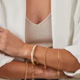 Esclava de alambre redondo en oro 9k con medalla colgante circular que presenta un diseño de estrella grabada con una circonia central.