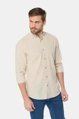 Camisa de lino color beige con cuello mao, manga larga, cierre frontal de botones y bordado sutil en el pecho.