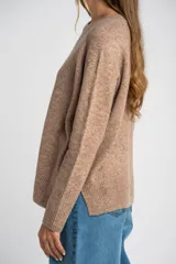 Sweater de tejido de punto color bordó, con cuello redondo, mangas largas y puños acanalados. Presenta un diseño de corte recto y textura suave.