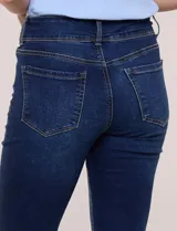 Jean elastizado de tiro alto y pierna semi-oxford, color azul, con diseño clásico de cinco bolsillos y dobladillo en el ruedo. Incluye un cinturón trenzado de cuerina marrón con hebilla metálica dorada.