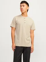 Remera básica de manga corta en color beige, con cuello mao y cartera corta con botones. Confeccionada en jersey de algodón.