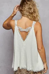 Top sin mangas color blanco hueso, con textura acanalada vertical y escote en V adornado con encaje festoneado.