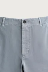 Pantalón chino para hombre de corte relajado, confeccionado en tejido de algodón con efecto lavado en color celeste. Cuenta con bolsillos delanteros, bolsillos traseros de vivo con botón y cierre frontal con cremallera y botón.