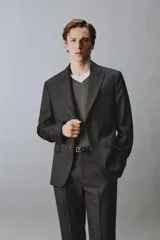 Blazer de corte regular confeccionada en lana de origen italiano, con diseño a cuadros sutiles. Presenta cuello con solapas de pico, cierre frontal de botones, bolsillos de solapa en la cadera y bolsillo de vivo en el pecho.