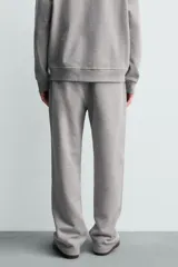Pantalón jogger de corte regular fit y color negro, confeccionado en tejido compacto de algodón con interior de rizo. Cuenta con cintura elástica, bolsillos frontales y un bolsillo trasero de doble vivo.