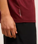 Remera deportiva masculina de manga corta con cuello redondo, confeccionada en tejido técnico con tecnología Dry para mayor transpirabilidad. Presenta detalles reflectantes en los hombros y un diseño liso en color verde melange.