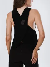 Chaleco de cuero marrón con diseño cruzado en la espalda y ajuste lateral mediante cordones. Presenta un corte holgado y moderno, ideal para usar como prenda de superposición.