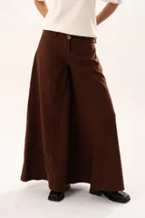 Pantalón de tiro medio con corte súper campana, confeccionado en tela de textura suave. Presenta cierre frontal con cremallera y botón, bolsillos delanteros y traseros, y costuras verticales que definen su estructura.