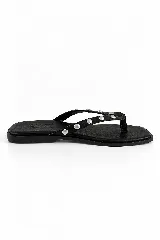 Ojota de cuero vacuno color negro con punta cuadrada y tiras delgadas decoradas con tachas metálicas plateadas.