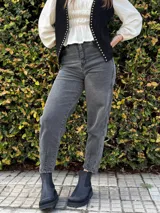 Jean estilo carrot de color negro gastado, con tiro alto y confeccionado en denim con lycra.