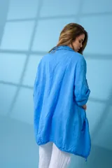 Campera larga de lino en color azul vibrante, con diseño abierto, mangas largas con detalle de ajuste mediante botón y bolsillos frontales discretos.