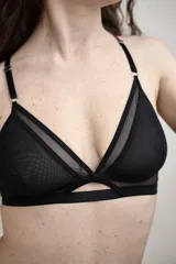 Soutien negro de diseño triangular con doble capa y copa suave de tul translúcido. Cuenta con tirantes ajustables y detalles metálicos.