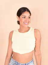 Musculosa crop top de tejido acanalado en color amarillo claro, con cuello redondo y dobladillo inferior en punta.