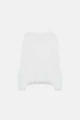 Jersey de cuello redondo y manga larga, color blanco, con bajo acabado en encaje combinado a tono.
