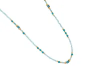 Collar de acero con terminaciones con baño de oro y piedras naturales de color celeste, azul y dorado.