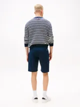 Pantalón corto tipo cargo de corte slim, confeccionado en algodón elástico. Presenta cierre de cremallera con botón, bolsillos laterales tipo cargo, bolsillos laterales ribeteados y bolsillos traseros de ojal. Incluye parche con logo de Tommy Jeans en la parte trasera.