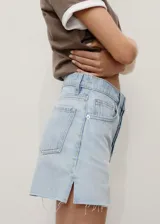 Short de denim celeste claro, con tiro medio, diseño de cinco bolsillos, presillas para cinturón y bajo deshilachado con pequeña abertura lateral.