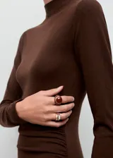 Vestido midi de punto fino color marrón chocolate, con cuello perkins, manga larga y diseño entallado con fruncidos laterales.