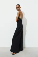 Mono largo negro de cuello halter y espalda descubierta, con pierna ancha. Cierre en espalda con cremallera oculta en costura y botones.