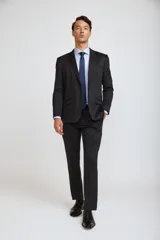 Ambo de corte slim compuesto por saco de dos botones con solapas clásicas y pantalón de vestir a juego, ambos en color gris oscuro.