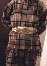 Sweater oversize de lana natural con diseño a cuadros, cuello alto y terminaciones con flecos torneados.