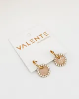 Aros tipo argolla dorados con dije circular con centro marmolado en tonos beige y borde con strass.