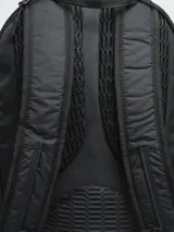 Mochila de trekking color negro, confeccionada en nylon ripstop. Cuenta con compartimento principal amplio, bolsillo frontal abierto, compartimento superior con cierre y pasadores exteriores para accesorios. Incluye tiras ajustables con broche frontal y cubre lluvia integrado.