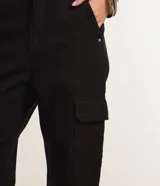 Pantalón de sarga color blanco roto, de corte recto y tiro alto, con bolsillos cargo laterales con solapa.