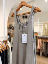 Mono largo de lino color beige, con escote en V, tirantes anchos, bolsillos laterales y silueta holgada. Cuenta con espalda ajustable mediante lazos.