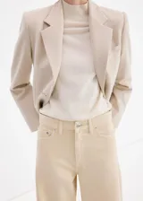 Jeans de corte wide leg y tiro medio, confeccionados en denim 100% algodón de color beige claro, con diseño de perneras amplias y rectas.