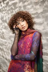 Vestido largo de tul con estampado abstracto en tonos violeta, fucsia, naranja y verde. Sin mangas, con cuello redondo y corte evasé. Incluye una bufanda de tul a juego.