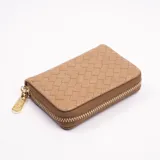 Billetera pequeña color beige con diseño tejido y cierre dorado.