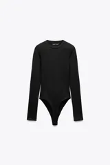 Body de manga larga con cuello redondo, confeccionado en una mezcla de algodón y modal, con cierre inferior mediante botones a presión.