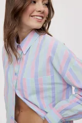 Camisa oversize de manga larga con estampado de rayas verticales en tonos rosado, celeste y verde menta. Cuenta con cuello camisero, cierre frontal con botones y un bolsillo aplicado en el pecho.