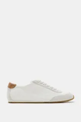 Zapatilla deportiva estilo blucher con pespuntes decorativos en el cuerpo, detalle de talonera en contraste de material y color, cierre mediante cordones y punta redonda.