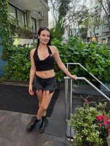 Top corto negro con escote drapeado y espalda descubierta.