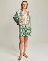 Camisa de viscosa con diseño estampado que combina motivos florales en el frente y patrón de cuadros en mangas y espalda. Presenta cuello clásico, cierre frontal con botones y mangas largas con puños definidos.