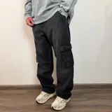 Pantalón jean cargo negro de corte recto y tiro medio, con bolsillos laterales con solapa.