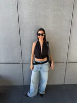 Top negro de cuello halter con escote pronunciado y diseño cruzado en el frente, corte corto.